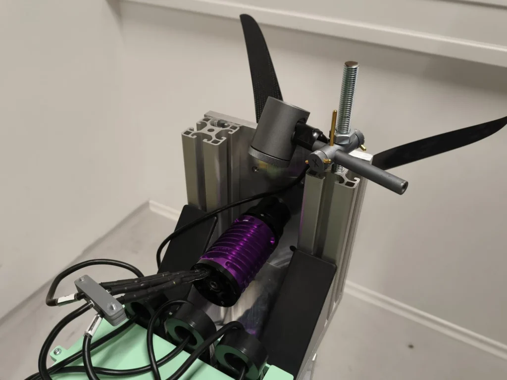 Schubprüfstand: Außenläufermotor mit Propeller auf einem Aluminiumprofil, darunter der Inverter auf einem grünen Halter